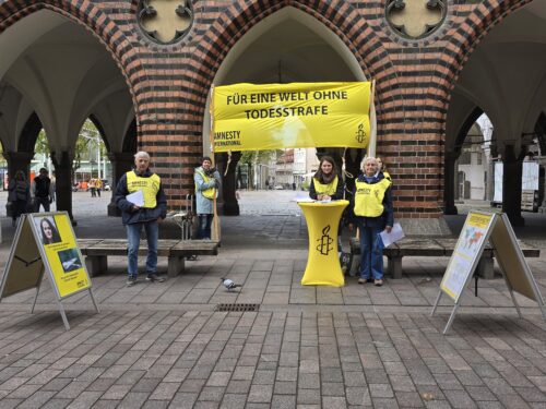 Mitglieder der Amnesty Gruppe Lübeck mit ihrem Infostand gegen die Todesstrafe bei den Rathausarkaden