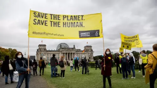 Demonstrierende mit einem Banner "Save the Planet! Save the Human!" beim Klimastreik in Berlin 2021